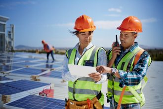Engineers using walkie-talkie and digital tablet at solar power plant Engineers using walkie-talkie and digital tablet at solar power plant